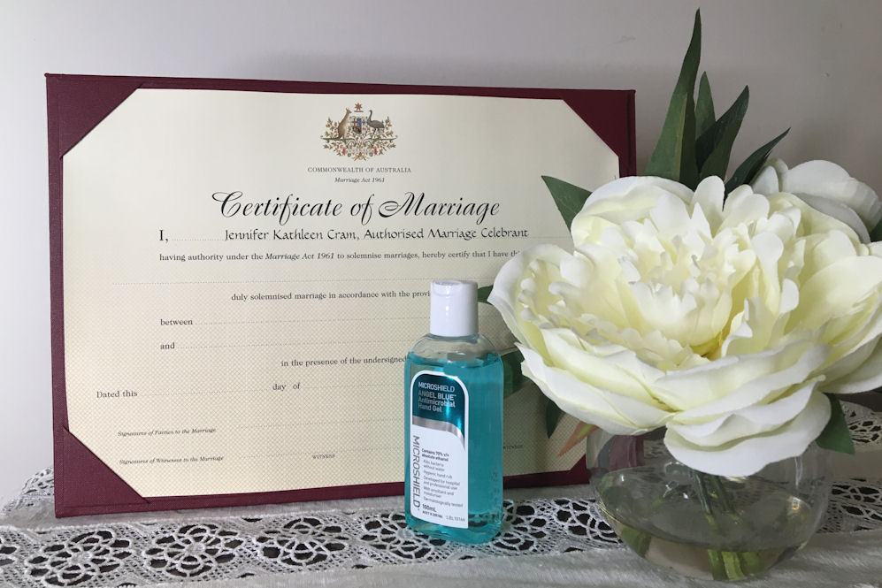 Marriage Certificate with White Peony in
                        glass vase and bottle of Hand Sanitiser