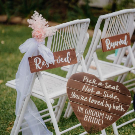 White aisle chairs
                        with wooden reserved signs