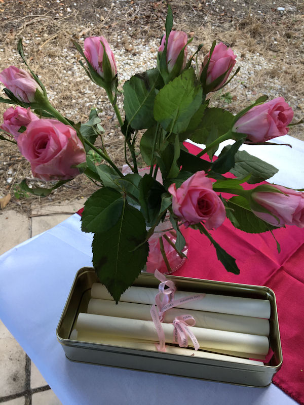 Naming Ceremony table with roses and scrolls
                  tied with Naming Day ribbon