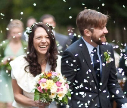 Paper Confetti being thrown over
                    bride and groom