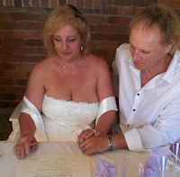 Laurence and Richard signing their marriage
                      certificate after their marriage by Jennifer Cram,
                      Brisbane Celebrant