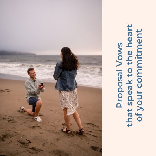 Man kneeling on a beach to propose marriage to
                  woman who is wearing a denim jacket. He wears dark
                  blue shorts and is holding an open ring box